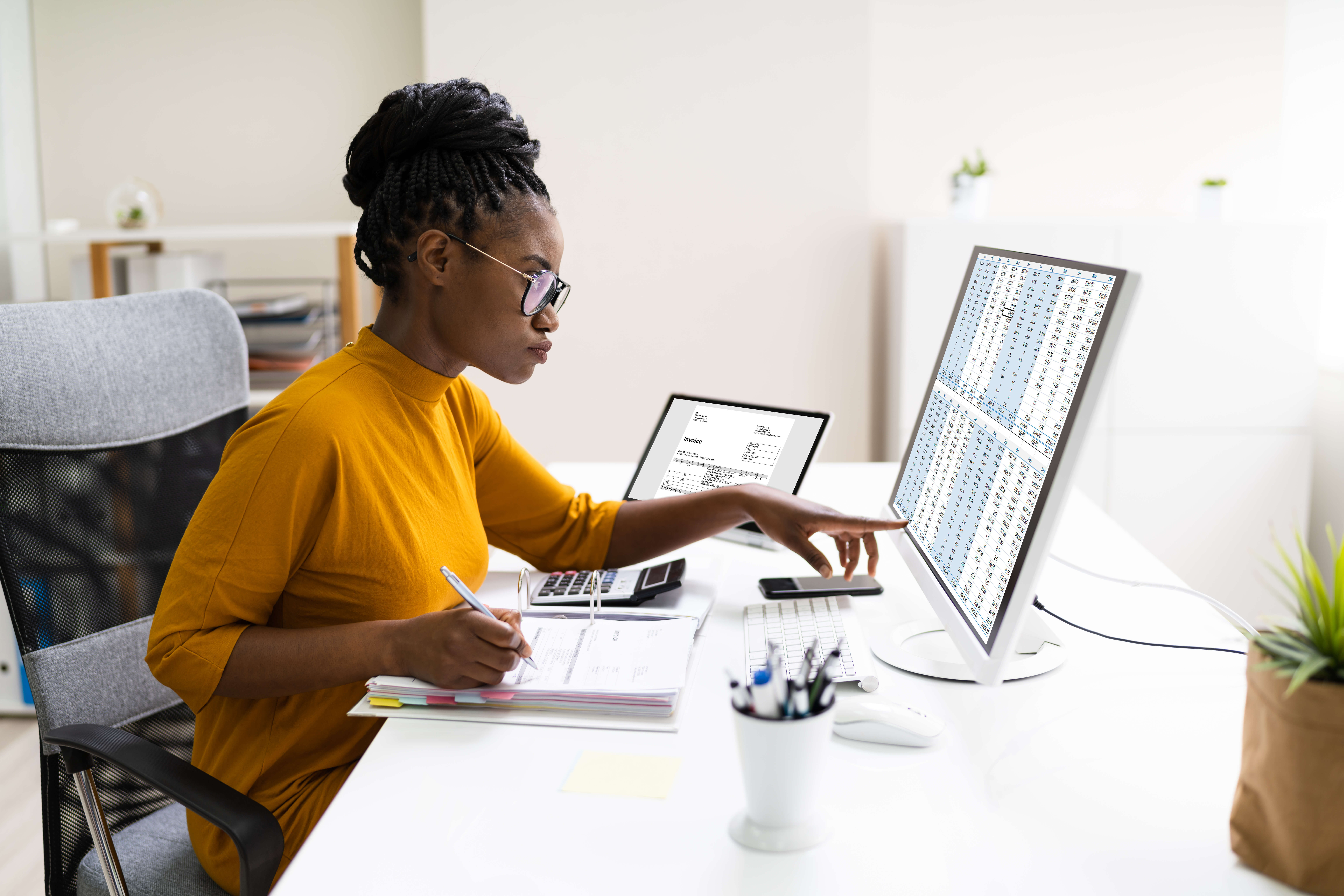 African,Professional,Chartered,Accountant,Woman,Doing,Tax Woman taking notes while pointing on the computer screen