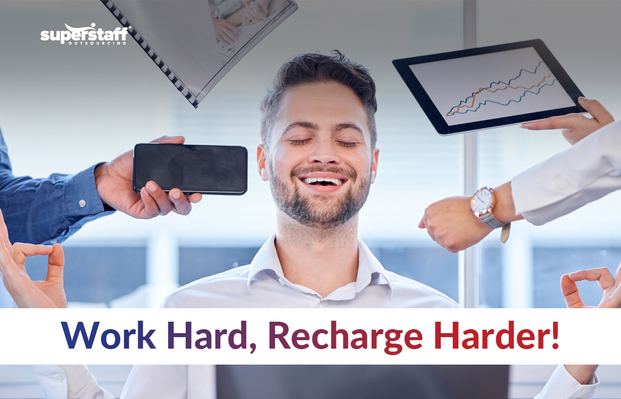 Maintaining Work-Life Balance in a Fast-Paced Environment: A professional smiling with eyes closed in a meditation pose while surrounded by work demands, symbolizing the importance of recharging amidst a busy schedule. The text overlay emphasizes 'Work Hard, Recharge Harder!' highlighting the need for balance in the workplace.